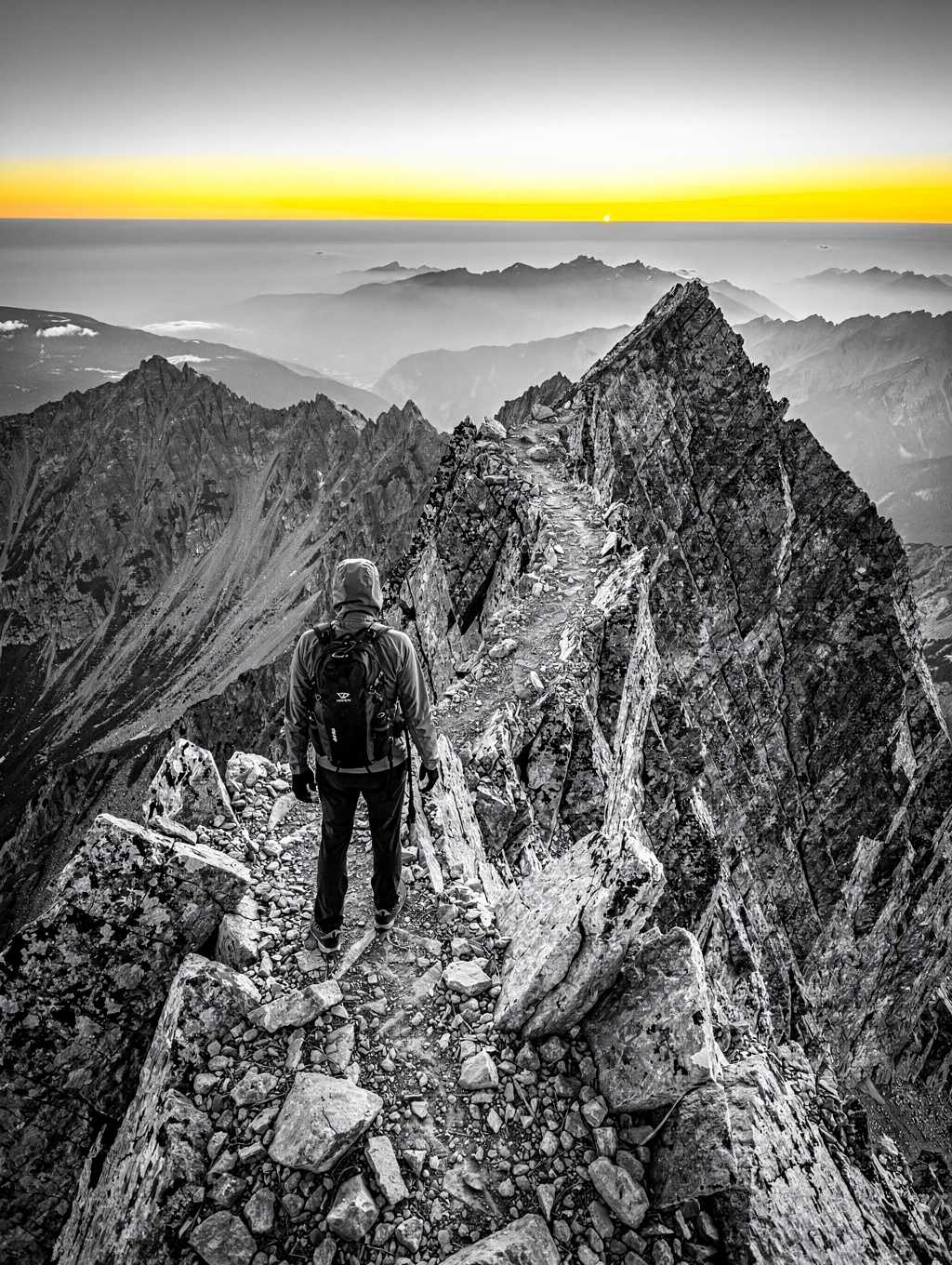High-contrast mountain climber reaching the peak